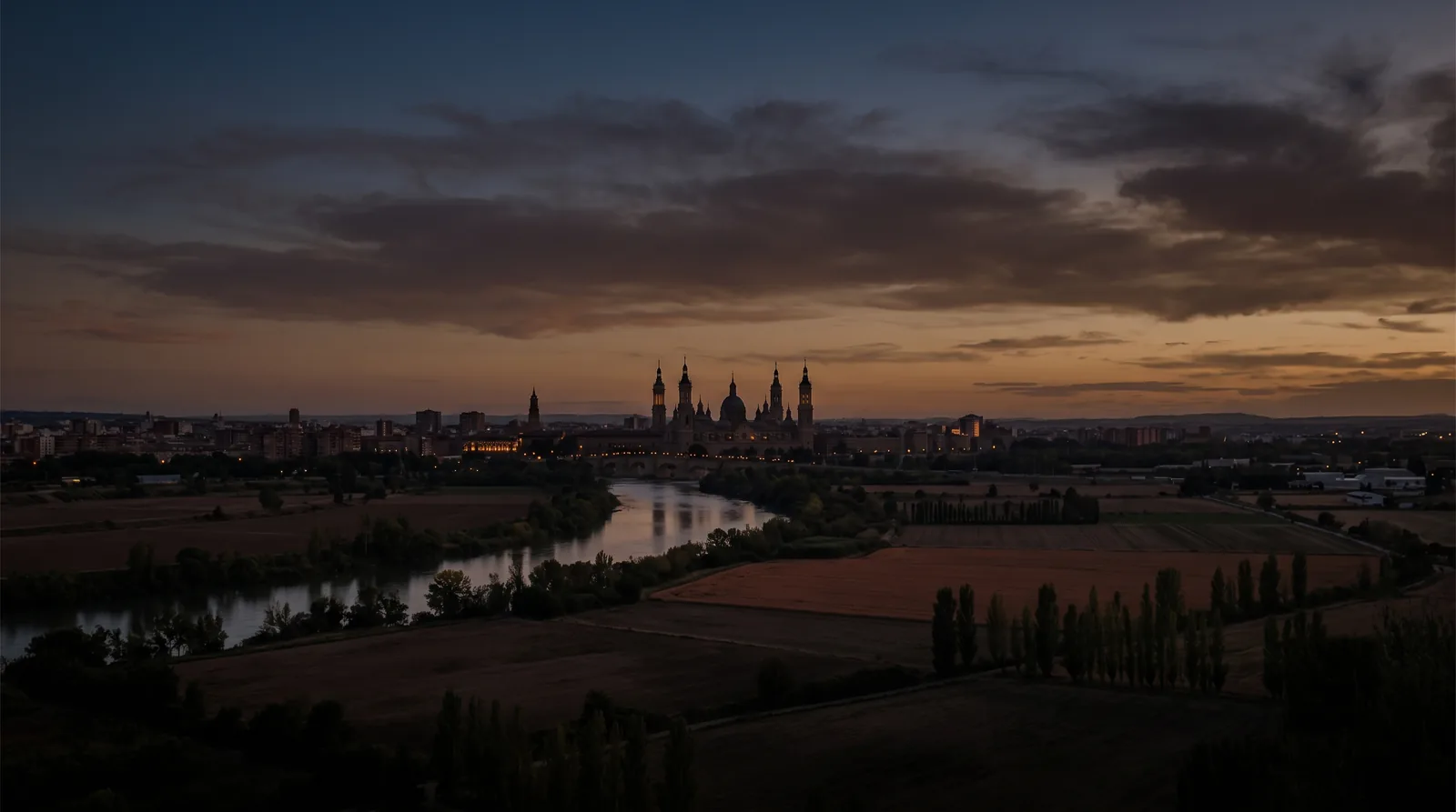 Vista panorámica de una ciudad española al caer la tarde, con las ventanas encendidas